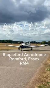 A casual vlog-style video showcasing a cafe located at an active aerodrome in Romford, Essex. The video features shots of small aircraft landing and taking off, alongside clips of the cafe's food offerings, including a cheese toastie, a full English breakfast, and a wrap with sweet potato fries.