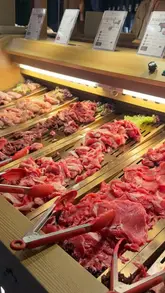 A video tour of a hotpot and BBQ restaurant in Leicester, showcasing the buffet selection of raw meats, vegetables, and sushi, as well as the individual cooking stations at each table.