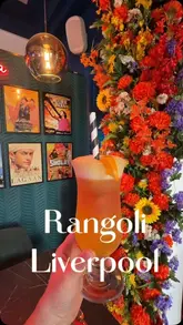 A promotional video for Rangoli in Liverpool, featuring a montage of the restaurant's interior, specifically highlighting its Indian cinema-themed decor, alongside shots of various dishes including prawns, curries, and a mocktail.