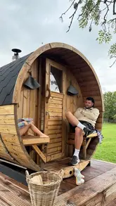 A family vlog showcasing a visit to 'The Sauna at the Cottage', featuring a wood-fired sauna, cold plunge pool, and a DIY wood-fired pizza lunch in a rural setting.