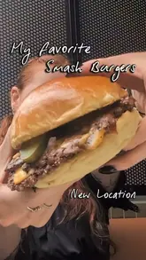 A short, energetic vlog-style video featuring a visit to a new Shakedown restaurant location. The creator highlights the menu items, including a smash burger, chicken tenders, fries, various dips, and a cheesecake dessert, while providing a brief tour of the new space.