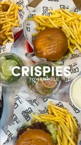 A review of the Crispies restaurant in Tower Hill, showcasing their menu of burgers, chicken wings, fries, and shakes, while highlighting the spacious interior and halal options.