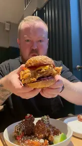 A vlog-style review of MilkBun in Clifton, Bristol, featuring two friends trying various menu items including burgers, wings, and fried pickles.