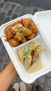 The video features a quick review of Ugly Dumpling in Soho, showcasing their gluten-free gyoza and tempura aubergine. The creator shows the exterior of the shop, the menu, and the food in a takeaway container.