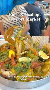 A short, energetic video showcasing a deluxe seafood boil at Rock & Scallop in Newport Market. The footage features close-ups of the seafood, including lobster tails and king prawns, being prepared and eaten by a group of friends, highlighting the interactive and social aspect of the meal.