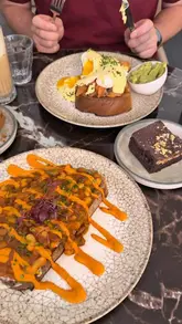 A short, music-led montage showcasing the exterior, interior, and brunch menu of Hampton & Vouis, featuring close-ups of eggs benedict, beans on toast, banana bread, a brownie, and coffee.