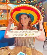 A promotional image for Newcastle Cocktail Week featuring a person wearing a large, colourful sombrero in a bar setting. The image is a straightforward, casual shot intended to highlight the upcoming event.