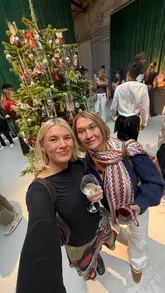 A fast-paced, vlog-style video featuring a creator and her mother attending a Waitrose Christmas tasting event. The video captures them sampling a variety of festive foods, including prawns, sausage rolls, turkey, and various drinks, while sharing their enthusiastic reactions.