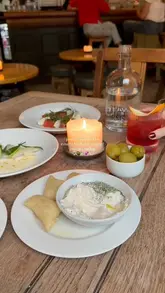 A short, aesthetic reel showcasing a dining experience at a Michelin-starred pub in London. The video features close-up shots of cocktails, appetizers like olives and bread with dip, a salad, a main meat dish, and a scotch egg being cut open. The atmosphere is cozy and intimate, highlighted by warm lighting and slow, deliberate camera movements.