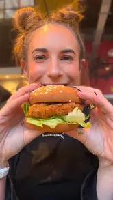 A creator reviews the new gluten-free fried chicken burger and Aji Verde sauce at Leon, highlighting the taste and dietary suitability.