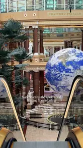 A short, atmospheric video featuring the 'Gaia' art installation, a large rotating globe suspended from the ceiling at Trafford Palazzo in Manchester, accompanied by text overlays.
