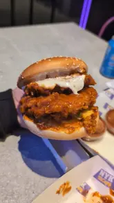 A short review of a new fried chicken spot in Birmingham, featuring a close-up of their signature spicy chicken burger and a look at the venue's exterior.