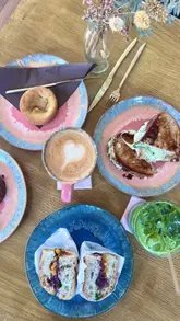 A short, aesthetic montage showcasing the interior, food, and drink offerings at Savour by Studio Chocolate, featuring close-ups of sandwiches, cookies, and a matcha latte.