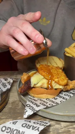 IY Stack burger with steak, bacon, pulled pork, cheese, gherkins, onion ring at Indigo Yard Edinburgh, cozy dining spot.