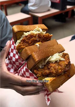 Generous chicken sandwich from Luckys Hot Chicken in London, showcasing crispy goodness and flavorful toppings.