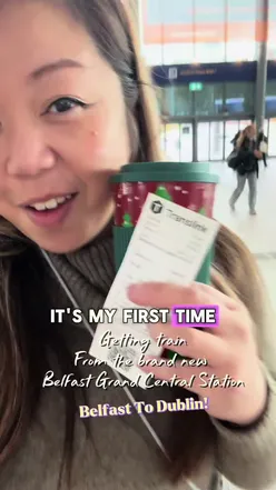 Traveler enjoying a scenic train ride from Belfast to Dublin, with tips for booking a ticket from Grand Central Station.