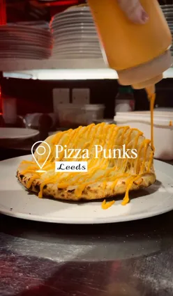 Thick, fluffy Sandough pizzas at Pizza Punks, Leeds, showcasing vibrant flavors and a lively atmosphere.