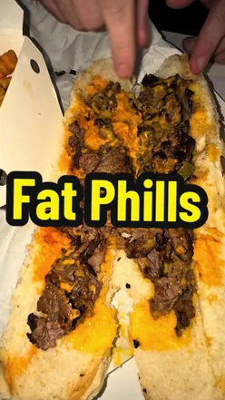 Enjoying a Philly cheesesteak and double cheese smash burger at Fat Phil's in Temple Bar, buzzing atmosphere and tasty bites.