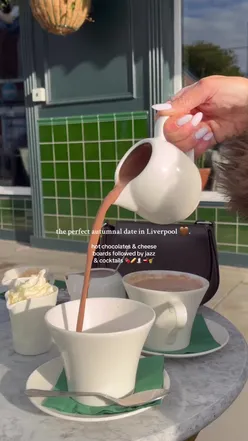 Couple enjoying a cozy afternoon on Lark Lane with hot chocolate, cheese board, and live jazz in Liverpool.