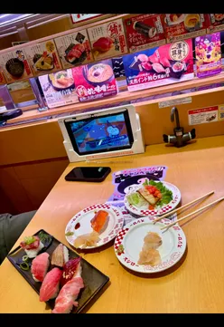 Affordable conveyor belt sushi experience in Tokyo for two, showcasing fun dining and delicious sushi varieties.