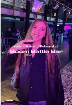 Couple enjoying cocktails and shuffleboard at BOOM BATTLE BAR for a fun date night in Birmingham.