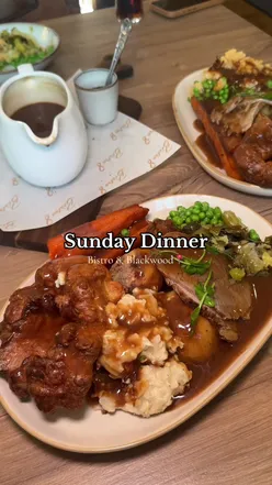 Diners enjoying a Sunday dinner featuring calamari, beef, lamb, and decadent desserts at a top-rated Bistro.