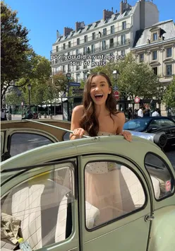 Tourists enjoying a vintage car ride through magical Paris, capturing the city's charm and beauty.