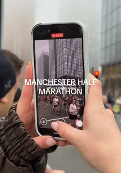 Participants and spectators enjoying the vibrant atmosphere of the Manchester Half Marathon in the city.