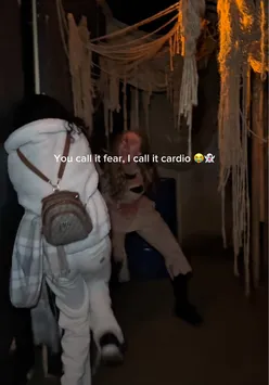 Visitors experiencing jump scares at The Howl Scream Park during Scarefest, laughing and counting jumps.