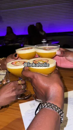 Friends clinking drinks at a lively gathering, enjoying good vibes and food together.