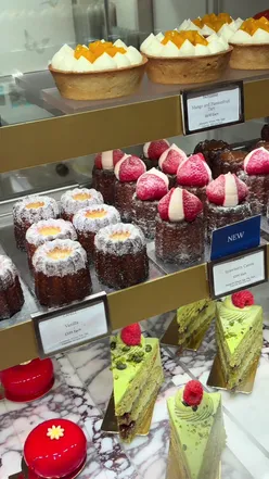 Indulge in luxury treats at Fortnum & Mason, featuring macarons, tarts, and exquisite cakes in London.