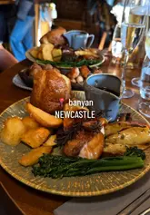Guests enjoying a bottomless Sunday roast at Banyan UK, featuring beef, chicken, and veggie options with drinks included.