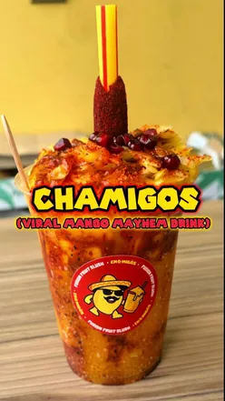 Mango Mayhem drink with mango slush, cubes, and tamarind straw at Chamigos in East London.