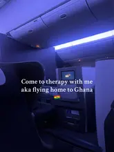 Traveler enjoying a business class flight with views over Ghana, highlighting a joyful homecoming.