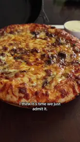 Delicious Birria Beef Pizza topped with melted cheese and fresh herbs, served on a rustic wooden table.