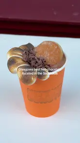 A short, punchy video showcasing a decadent hot chocolate topped with a toasted marshmallow and a donut hole from Kitty's Donuts in Glasgow. The video features close-up shots of the drink and a quick pan of the donut display case.