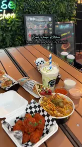 A promotional video showcasing various food and drink items from Road House Kitchen, including wings, loaded fries, wraps, and milkshakes, filmed at their outdoor seating area in Birmingham.