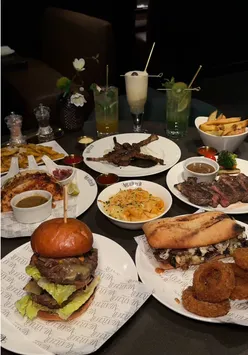 Halal dining at Meat Club in Broadway Plaza, featuring steak sandwich, burger, and tacos in trendy interior.