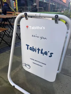 Customers enjoying coffee and pastries at Tabitha's cafe in Manchester, featuring cozy decor and vibrant atmosphere.