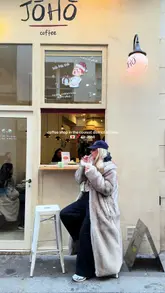 A short, aesthetic video tour of Jōhō coffee shop in Paris, featuring shots of the exterior, interior decor, menu, and close-ups of matcha and iced lattes alongside pastries.