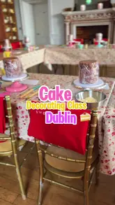 A vlog-style video documenting a cake decorating workshop at Airfield Estate in Dublin, featuring the process of decorating a four-tier cake and a lunch break.