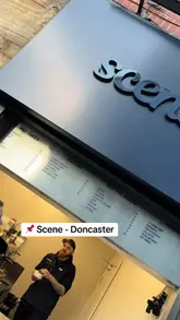 A short, handheld video showcasing a matcha cafe in Doncaster. The video features a quick pan of the menu board followed by close-up shots of a barista preparing two vibrant, layered matcha drinks.