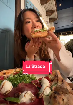 Delicious pizza enjoyed at La Strada Pizzeria, Dublin, with a scenic Sicilian backdrop.