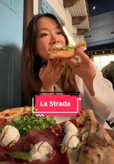 Delicious pizza enjoyed at La Strada Pizzeria, Dublin, with a scenic Sicilian backdrop.