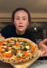 A creator unboxes and assembles a 'Dough Bros' at-home pizza kit, demonstrating the ingredients and the final result.
