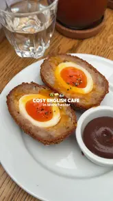 A short, engaging review of a cafe in Manchester's Northern Quarter, highlighting various British comfort food items including a Scotch egg, hash browns, and a Northern rarebit.