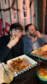 Friends enjoying bottomless brunch with pizza, burgers, cocktails, and mini golf in the vibrant Golf Fang Cardiff venue.