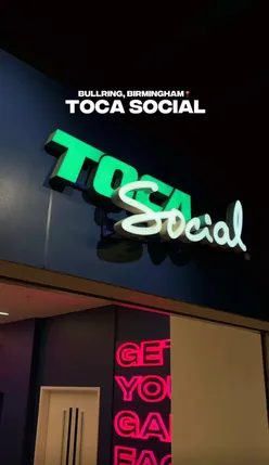 Guests playing a fun immersive football game at Toca Social Birmingham, with food, cocktails, and a lively atmosphere.
