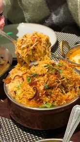 Assortment of vibrant Indian curries, fluffy basmati rice, and freshly baked naan bread at Ranmoor Bawarchi in Sheffield.