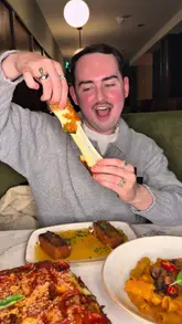A food review video featuring a visit to Deano's in Manchester, highlighting their mozzarella sticks, deep-dish focaccia pizza, rigatoni alla vodka, and garlic twists, while showcasing the restaurant's moody interior and cocktail menu.